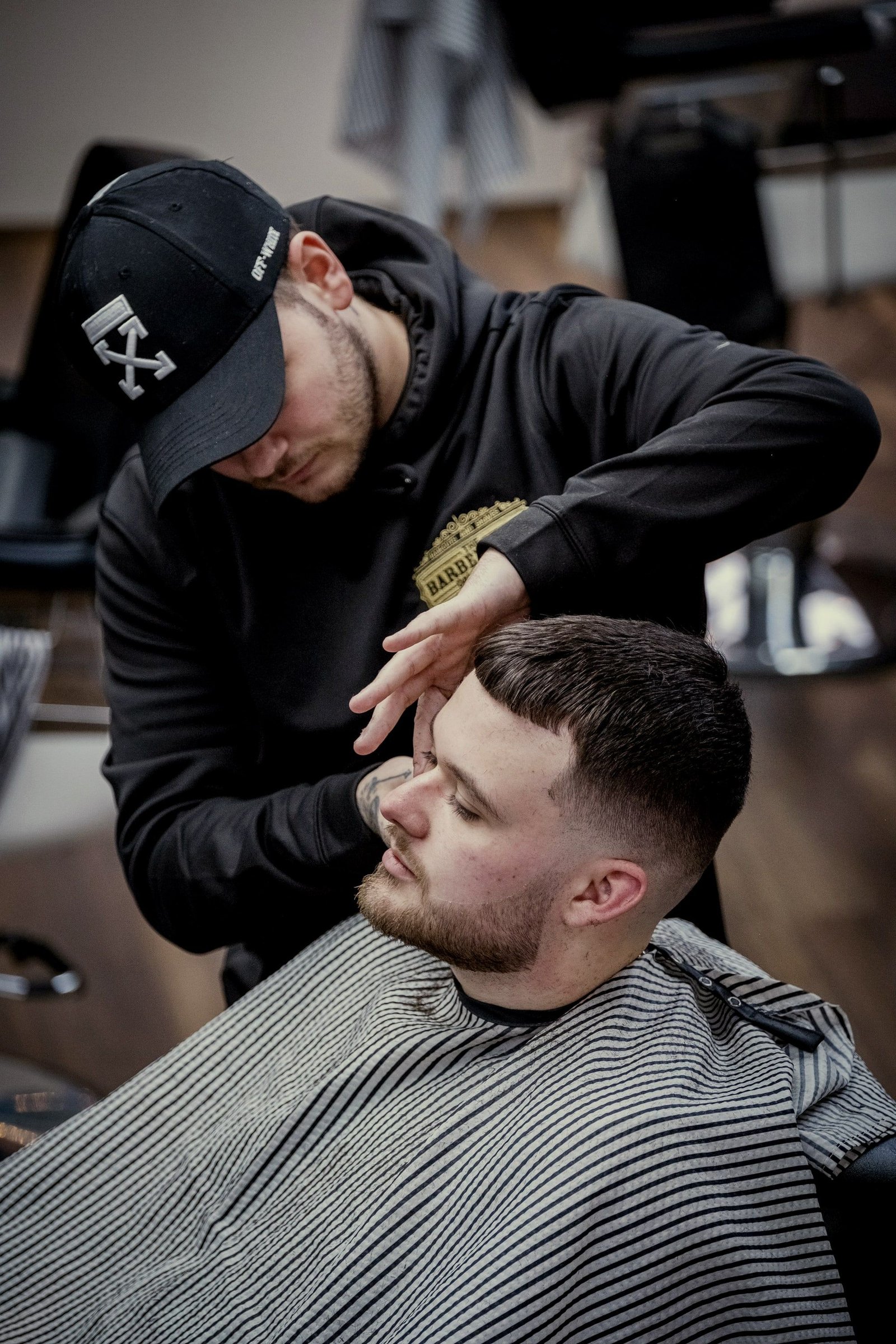 El barbero perfila un degradado a máquina en la nuca de un cliente