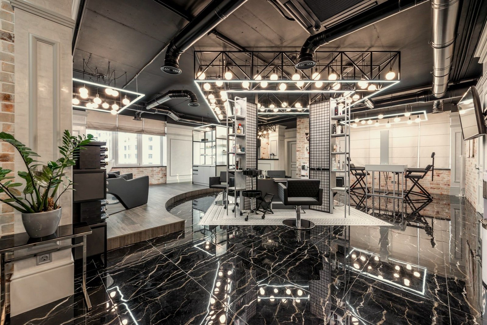 Salón con piso de mármol negro, luces de camerino y sillones alineados